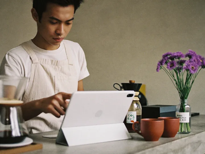 Barista menyentuh tablet kasir di meja beton di samping alat seduh manual